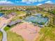 A vibrant aerial view shows the tennis and volleyball courts with lake community ramadas and walking paths at 15663 S 183Rd Dr, Goodyear, AZ 85338