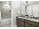 Bathroom with double sink vanity, granite countertops, and bath/shower combo with tiled backsplash at 15663 S 183Rd Dr, Goodyear, AZ 85338