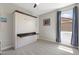 Neutral bedroom featuring a murphy bed with a small work surface, window, and ceiling fan at 15663 S 183Rd Dr, Goodyear, AZ 85338