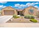 Front exterior featuring desert landscaping, a two-car garage, and a welcoming front porch at 15663 S 183Rd Dr, Goodyear, AZ 85338