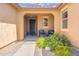 Inviting front porch with seating, desert plants, and a stylish entrance door at 15663 S 183Rd Dr, Goodyear, AZ 85338