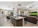 Kitchen island with seating, open to the living room and dining area with great lighting at 15663 S 183Rd Dr, Goodyear, AZ 85338