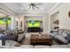 Spacious living room with sofas, tile floors, ceiling fan, and large TV with a view to the outside at 15663 S 183Rd Dr, Goodyear, AZ 85338