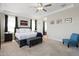 Comfortable main bedroom with a king bed, tray ceiling, ensuite bathroom and a sitting chair at 15663 S 183Rd Dr, Goodyear, AZ 85338