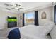 Comfortable main bedroom with a king bed, ceiling fan, and dresser with television and view of the outside at 15663 S 183Rd Dr, Goodyear, AZ 85338