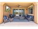 Covered patio with outdoor seating area and a view through sliding glass doors of the swimming pool at 15663 S 183Rd Dr, Goodyear, AZ 85338