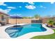 Backyard pool with a clean patio, beautiful blue water, and outdoor umbrella providing shade at 15663 S 183Rd Dr, Goodyear, AZ 85338