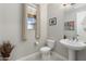 Bright powder room with pedestal sink, decorative art, and window with neutral curtains at 15663 S 183Rd Dr, Goodyear, AZ 85338