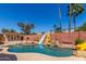 Backyard with a pool, waterslides, palm trees, and a red brick fence at 15825 N 45Th St, Phoenix, AZ 85032