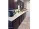 Updated kitchen featuring stone countertops, dark wood cabinets, a mosaic tile backsplash, and stainless appliances at 17823 N 99Th Dr, Sun City, AZ 85373