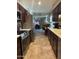 Open concept kitchen with stainless steel appliances, stone countertops, and dark wood cabinetry at 17823 N 99Th Dr, Sun City, AZ 85373
