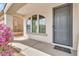 Charming front entrance features a gray door, arched windows, and a covered porch, creating a welcoming curb appeal at 18286 La Posada Ct, Gold Canyon, AZ 85118