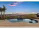 Private backyard featuring a pool with rock features, mature trees, and panoramic sunset views at 18401 N 14Th St, Phoenix, AZ 85022