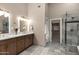 Luxurious bathroom with double vanity, marble floors, elegant lighting, and glass-enclosed shower at 18401 N 14Th St, Phoenix, AZ 85022