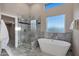Spa-like bathroom features a soaking tub, glass shower, and natural light at 18401 N 14Th St, Phoenix, AZ 85022