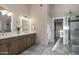 Beautiful bathroom with marble floors, dual sinks, and a glass enclosed shower and a walk-in closet at 18401 N 14Th St, Phoenix, AZ 85022