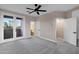 Open bedroom featuring carpet flooring, large windows, and an open doorway to a bathroom at 18401 N 14Th St, Phoenix, AZ 85022