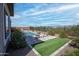 This backyard includes a pool, artificial turf, and beautiful desert landscaping at 20210 N Wagner Wash Dr, Buckeye, AZ 85396