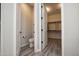 This bathroom includes a toilet and gray wood tile flooring with a view of a walk-in closet with shelving at 20210 N Wagner Wash Dr, Buckeye, AZ 85396