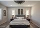 This bedroom includes wood tile flooring, a king bed, and two windows with shutters for natural light at 20210 N Wagner Wash Dr, Buckeye, AZ 85396