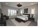 This bedroom includes wood tile flooring, a king bed, and two windows with shutters for natural light at 20210 N Wagner Wash Dr, Buckeye, AZ 85396