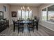 Elegant dining room featuring modern chandelier, large window, and stylish tile flooring at 20210 N Wagner Wash Dr, Buckeye, AZ 85396