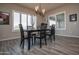 Dining room featuring modern chandelier, table with seating for six, and plantation shutters at 20210 N Wagner Wash Dr, Buckeye, AZ 85396