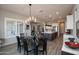 Beautiful dining area with elegant chandelier and gray wood-look tile, open to a spacious modern kitchen at 20210 N Wagner Wash Dr, Buckeye, AZ 85396
