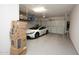 Garage featuring epoxy floors, storage, and a modern car, providing a clean and organized space at 20210 N Wagner Wash Dr, Buckeye, AZ 85396