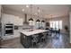 Open kitchen with an island, pendant lighting, white cabinetry, and stainless appliances at 20210 N Wagner Wash Dr, Buckeye, AZ 85396