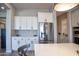 Bright kitchen featuring white cabinets, stainless steel refrigerator, and plenty of counter space at 20210 N Wagner Wash Dr, Buckeye, AZ 85396