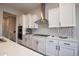 Modern kitchen features white cabinets, stainless steel appliances, and a stylish backsplash at 20210 N Wagner Wash Dr, Buckeye, AZ 85396