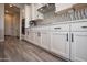 Kitchen featuring white cabinets with dark hardware, quartz countertops, and stainless steel appliances at 20210 N Wagner Wash Dr, Buckeye, AZ 85396