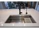 Stylish kitchen sink with stainless steel drying rack and sleek faucet fixtures at 20210 N Wagner Wash Dr, Buckeye, AZ 85396
