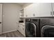 Well-equipped laundry room with modern appliances and ample storage in white cabinets at 20210 N Wagner Wash Dr, Buckeye, AZ 85396