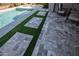 A beautifully designed patio with travertine tiles and artificial turf accents provides an inviting outdoor space at 20210 N Wagner Wash Dr, Buckeye, AZ 85396