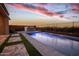 Stunning outdoor pool and kitchen area, perfect for entertaining with beautiful sunset at 20210 N Wagner Wash Dr, Buckeye, AZ 85396