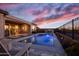 Inviting backyard pool with patio, outdoor kitchen, and scenic sunset views at 20210 N Wagner Wash Dr, Buckeye, AZ 85396