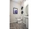 Stylish powder room with pedestal sink, modern fixtures, and decorative wall art at 20210 N Wagner Wash Dr, Buckeye, AZ 85396