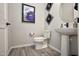 Stylish powder room with pedestal sink, modern fixtures, and decorative wall art at 20210 N Wagner Wash Dr, Buckeye, AZ 85396