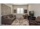 Cozy sitting room showcases neutral walls, plush sofa, patterned rug, and lots of natural light at 20210 N Wagner Wash Dr, Buckeye, AZ 85396