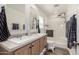 Bright bathroom featuring double sinks, a shower with glass door, wood-look flooring, and modern fixtures at 2060 N Center St # 138, Mesa, AZ 85201