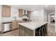 Bright kitchen featuring an island with barstool seating, stainless steel appliances, and light wood cabinets at 2060 N Center St # 138, Mesa, AZ 85201