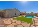 Spacious backyard with artificial grass, stepping stones, and refreshing pool at 2122 W Alta Vista Rd, Phoenix, AZ 85041