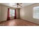 This bedroom is bright and airy with wood-look floors, neutral walls, ceiling fan, and two windows at 2122 W Alta Vista Rd, Phoenix, AZ 85041