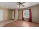 Bright living room with wood-look flooring, neutral walls, ceiling fan and a large window with red drapes at 2122 W Alta Vista Rd, Phoenix, AZ 85041