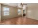 Spacious main bedroom featuring wood laminate flooring, ceiling fan, and an ensuite bathroom at 2122 W Alta Vista Rd, Phoenix, AZ 85041