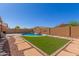 View of the backyard with artificial grass, stepping stones and refreshing pool at 2122 W Alta Vista Rd, Phoenix, AZ 85041