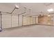 Spacious three car garage with three garage doors, overhead lighting, and ample space at 21373 N 94Th Ave, Peoria, AZ 85382