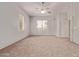 Open main bedroom with large windows, neutral walls and carpet flooring with ceiling fan at 21373 N 94Th Ave, Peoria, AZ 85382